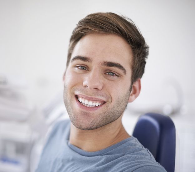 Smiling young man in dental chair
