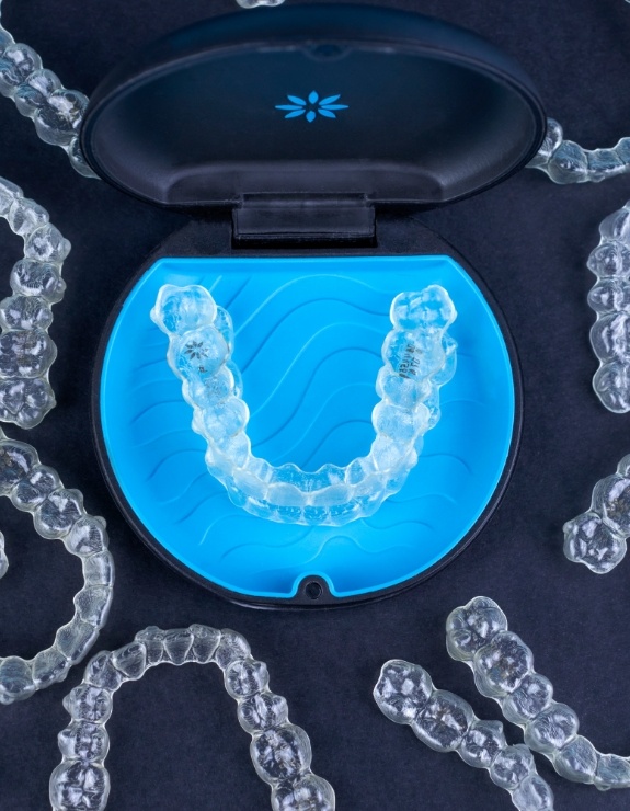 Several Invisalign clear aligners on a desk