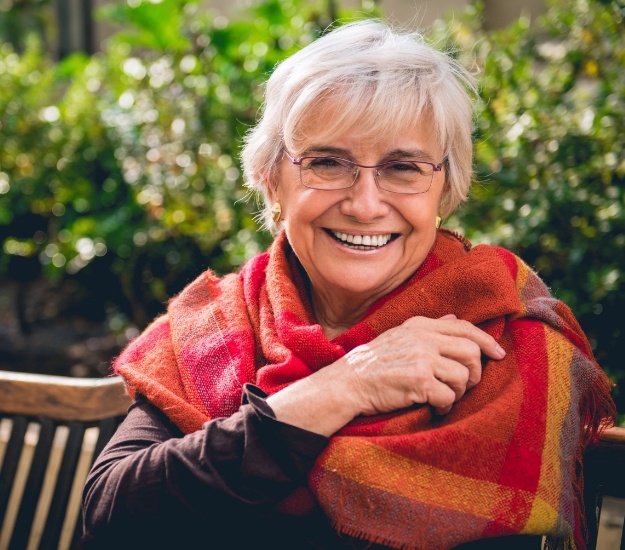 Senior woman in orange shawl smiling outdoors
