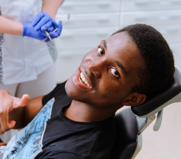Man giving thumbs up in dental chair