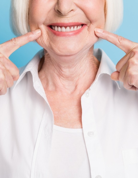 Close up of senior woman pointing to her smile