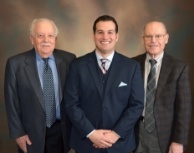 Three smiling dentists in suits