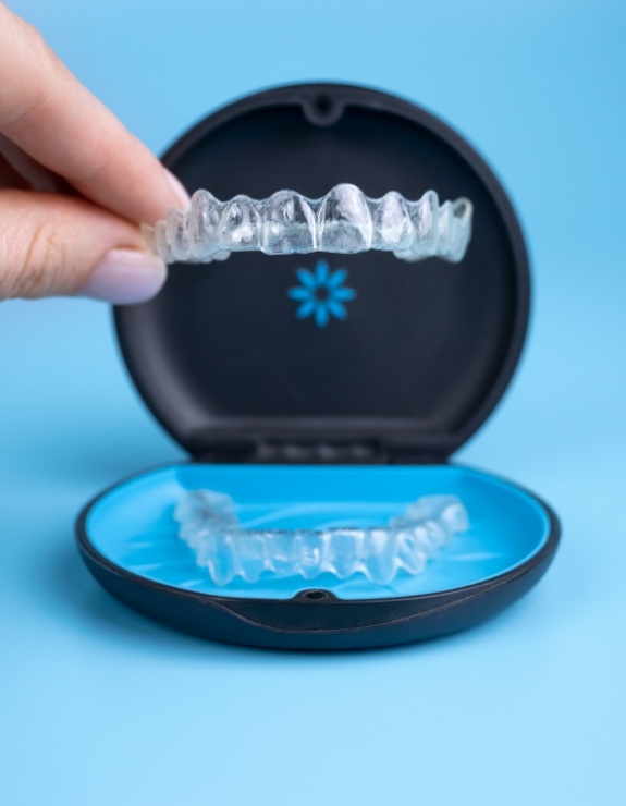 Person placing an Invisalign tray in its storage case