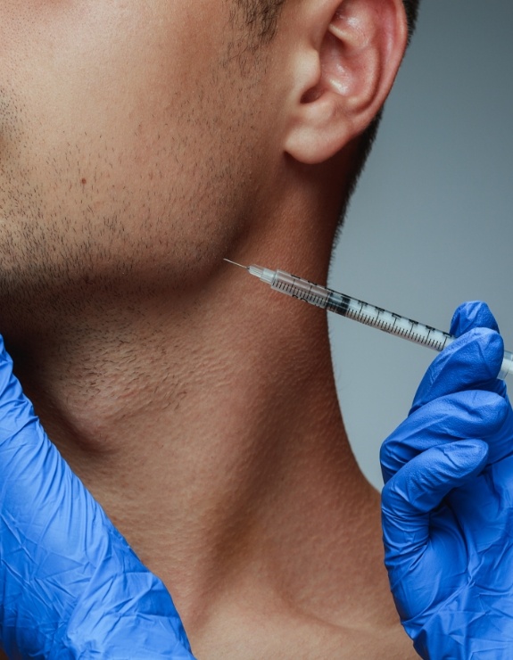 Close up of man receiving Botox injection in his jaw