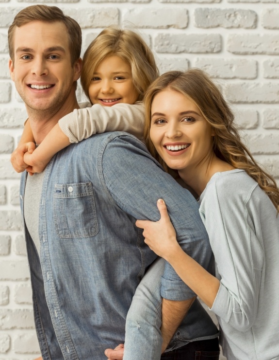 Family of three smiling in Arlington Heights dental office