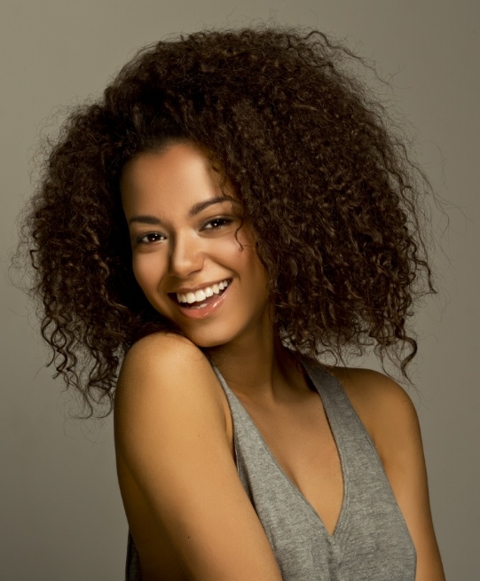 Young woman in gray blouse smiling after cosmetic dentistry in Arlington Heights