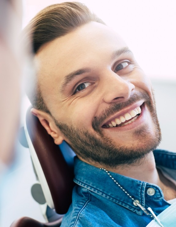 Smiling man leaning back in dental chair