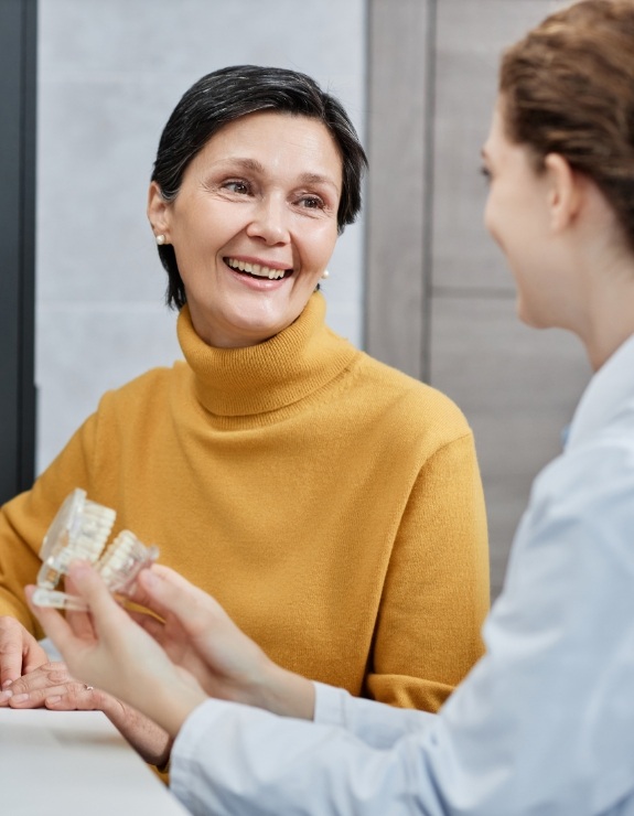 Woman in yellow sweater talking to dentist