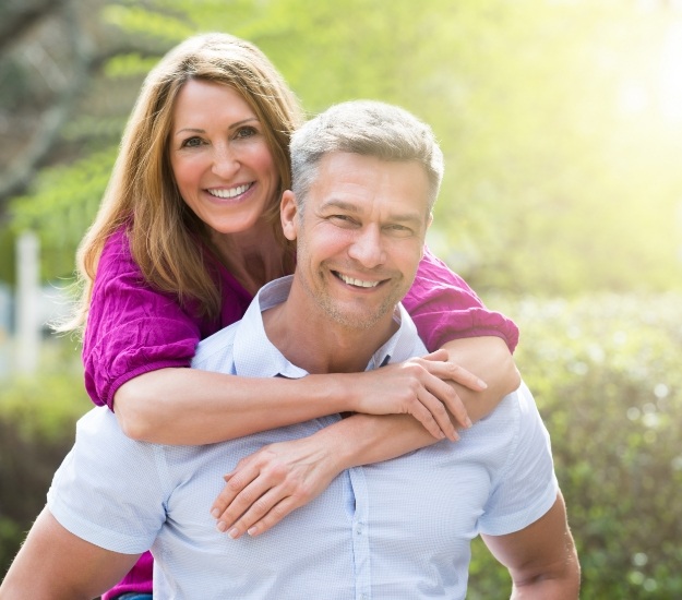 Woman hugging man from behind outdoors