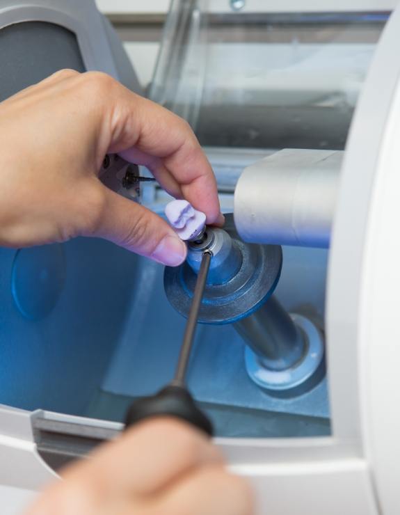 Dentist holding ceramic block in same day dental crown machine