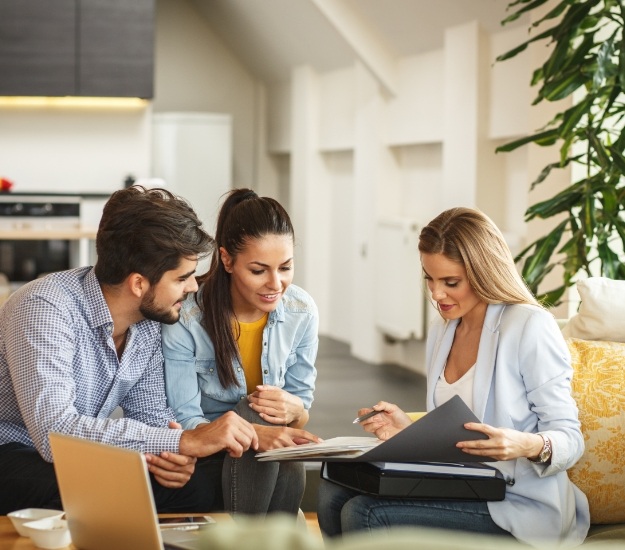 Three people at table looking at paperwork