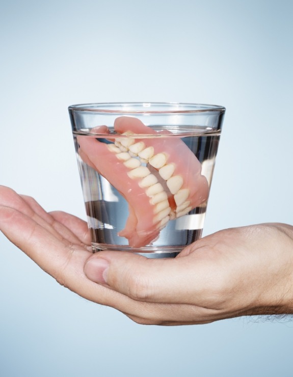 Dentures soaking in glass of water