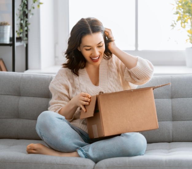 Woman excitedly opening a cardboard box