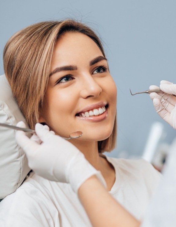 Woman in dental chair smiling at her dentist