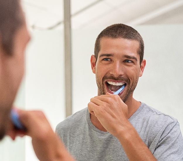 Patient in Arlington Heights brushing their dental implants