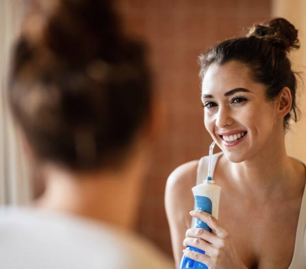  Patient in Arlington Heights using water flosser on dental implants