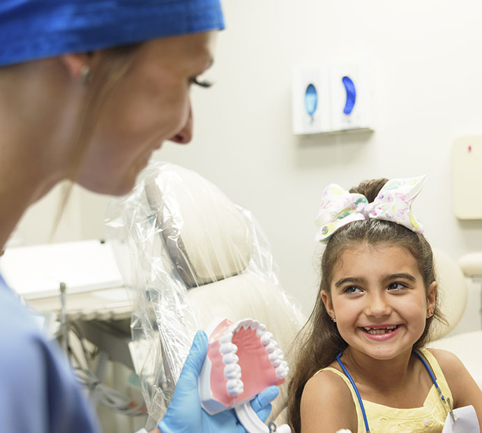 Dental team member walking down hallway with senior man