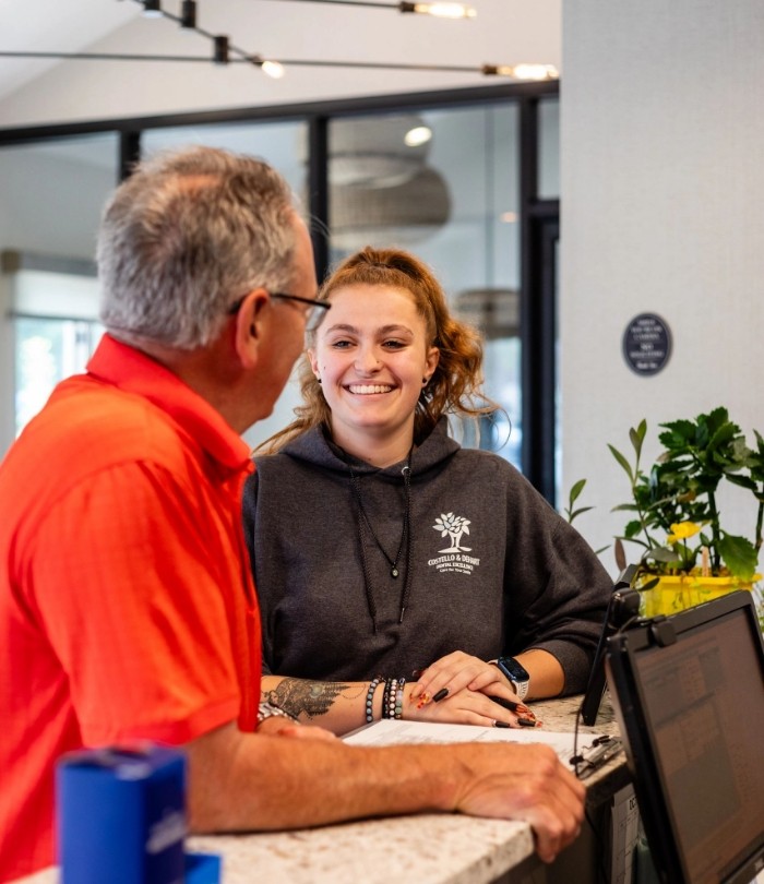 Arlington Heights dental team member talking to a patient at front desk