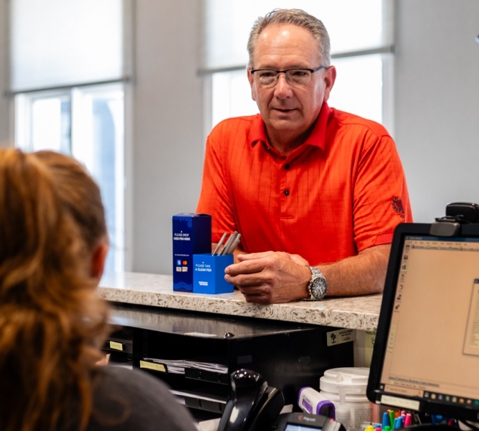 Senior man talking to receptionist in Arlington Heights dental office