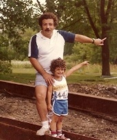 Photograph from several decades ago of father and son in forest pointing to trees