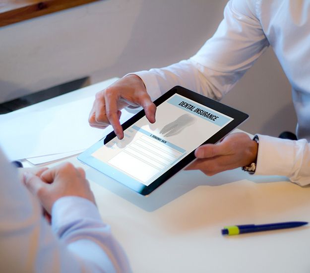 Patient reviewing dental insurance forms on tablet