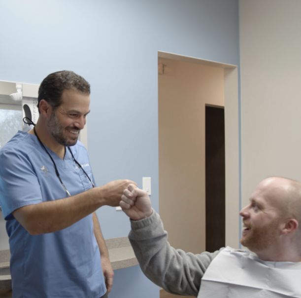 Arlington Heights dentist Doctor Ernie Costello giving a patient a high five