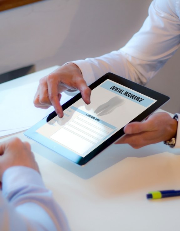 Two people looking at dental insurance information on tablet