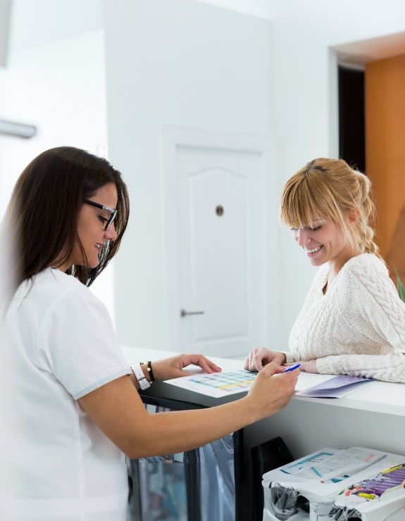 Dental team member showing a clipboard to a patient