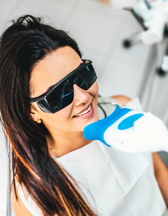 Woman in dental chair getting professional teeth whitening