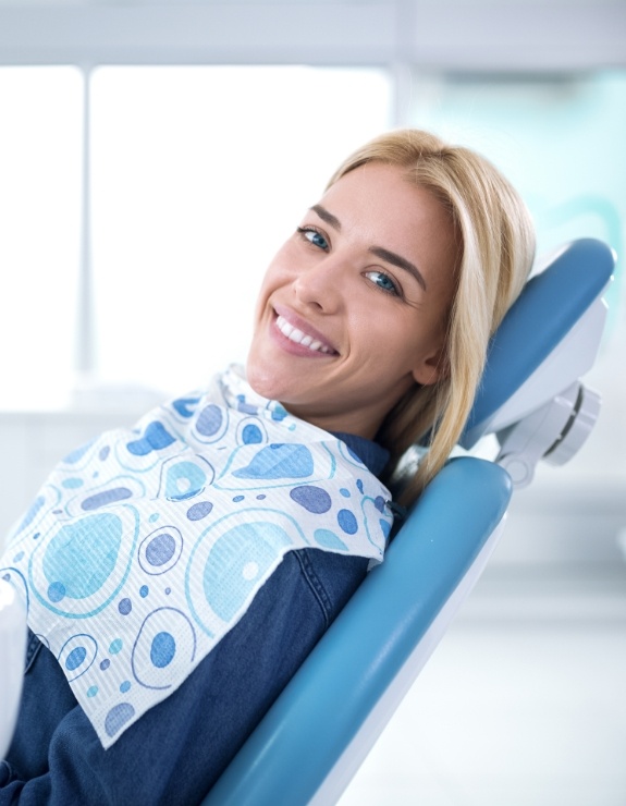 Smiling woman leaning back in dental chair