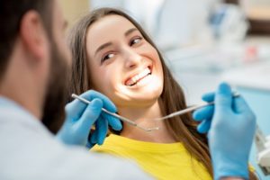 Smiling woman getting a root canal from her Arlington Heights dentist