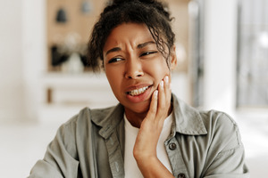 Woman in jacket suffering from jaw pain